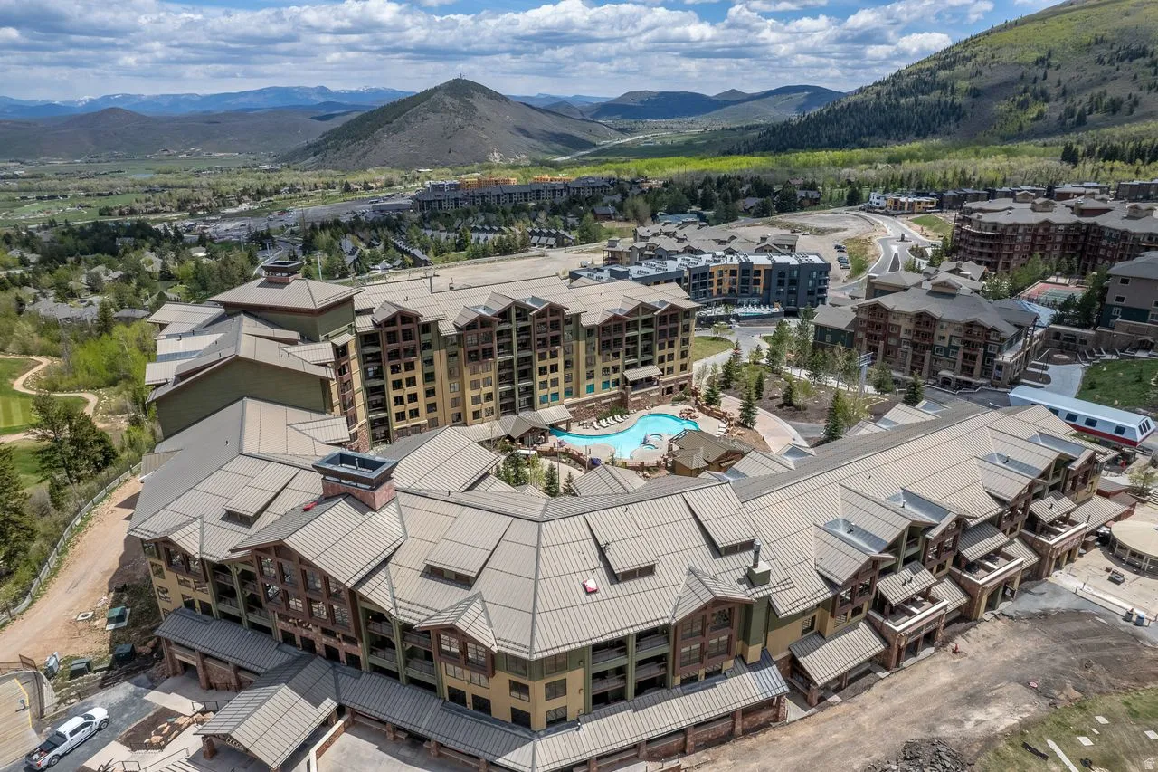 Expansive multi-story building featuring a central outdoor pool area and surrounding mountain and valley scenery