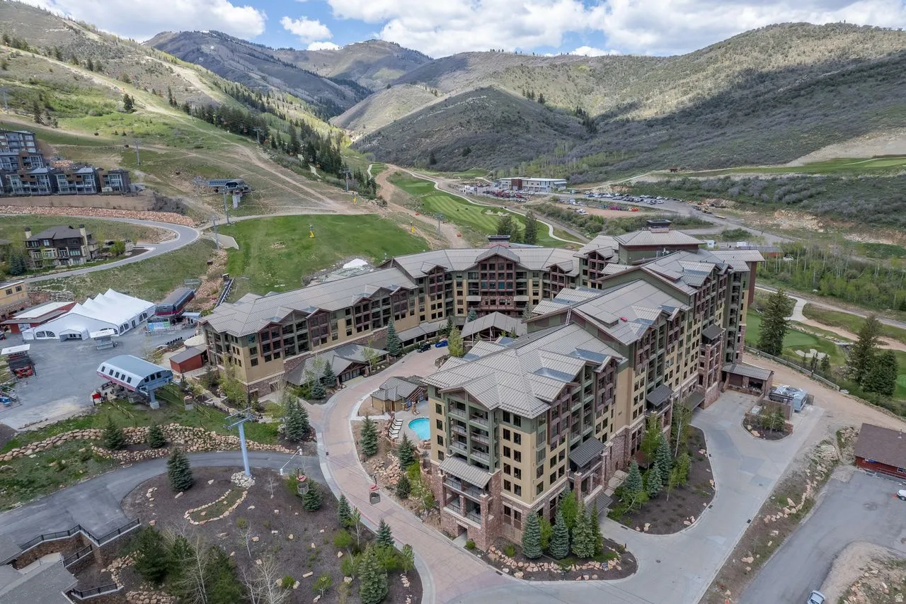 Multi-story resort-style building featuring a tiered architectural design, multiple balconies, and a central courtyard pool