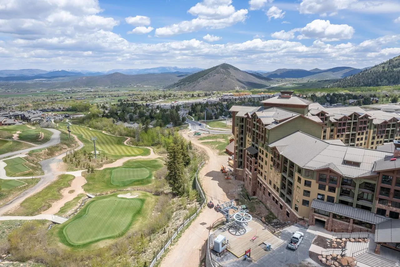 Multi-story building featuring extensive fenestration, wood-tone siding, and stone accents