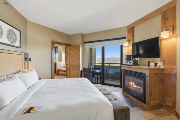 Bedroom featuring a built-in fireplace with a stone hearth, wood-finish mantel, and integrated television