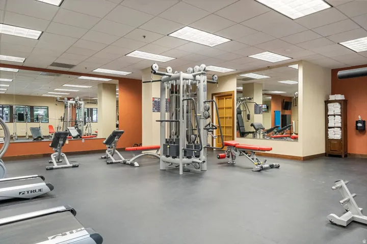 Fitness area featuring padded flooring and mirrored walls