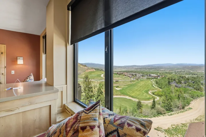 Panoramic landscape with expansive golf course, framed by large windows with roller shades