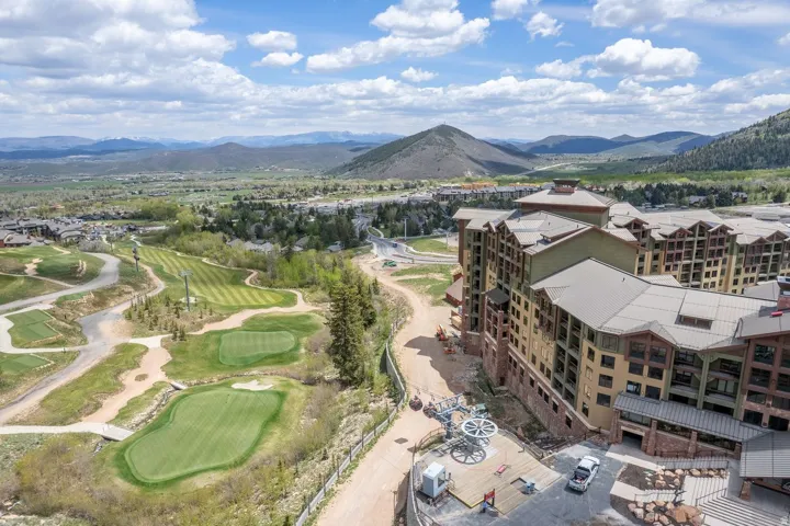 Multi-story building featuring extensive fenestration, wood-tone siding, and stone accents