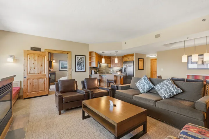 Open-concept living area with a built-in electric fireplace, warm wood-finish cabinetry, and stainless steel appliances