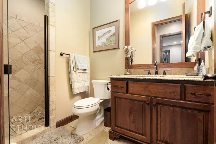 Bathroom featuring a dark wood vanity with granite countertop, undermount sink, and oil-rubbed bronze fixtures