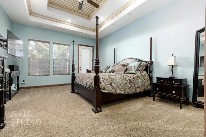 Light blue walls with a tray ceiling featuring wood paneling