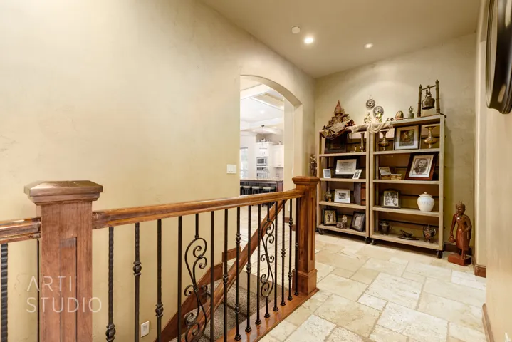 Staircase featuring wood railings and decorative iron balusters