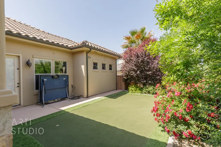 Exterior patio featuring a putting green, stucco siding, and a tile roof