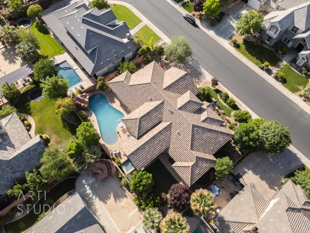 Expansive property featuring a tiled roof, a large, freeform swimming pool, and mature landscaping