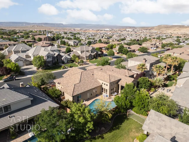 Single-story residence with a multi-level tile roof, featuring a private swimming pool, mature perimeter landscaping, and a fenced backyard area
