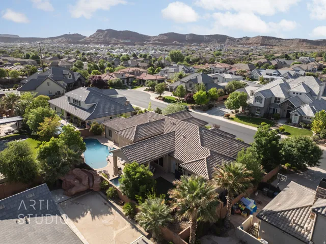 Expansive residential property featuring a large backyard swimming pool, mature palm trees, and a rock formation