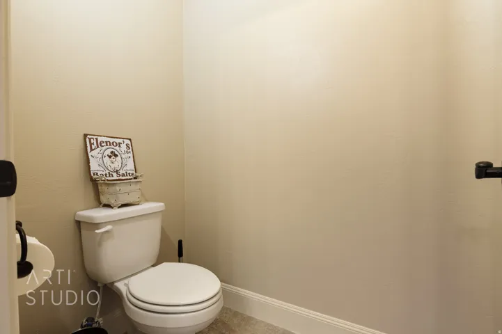 White porcelain toilet with a matching tank and seat, light neutral wall paint, and white baseboards