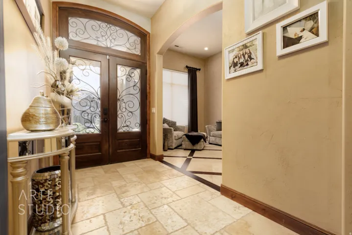 Double entry doors with decorative ironwork and an arched transom