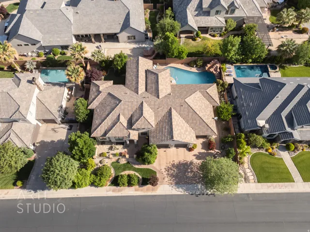 Expansive property featuring a multi-gabled tile roof, a private swimming pool with rock waterfall, and a generous paved driveway