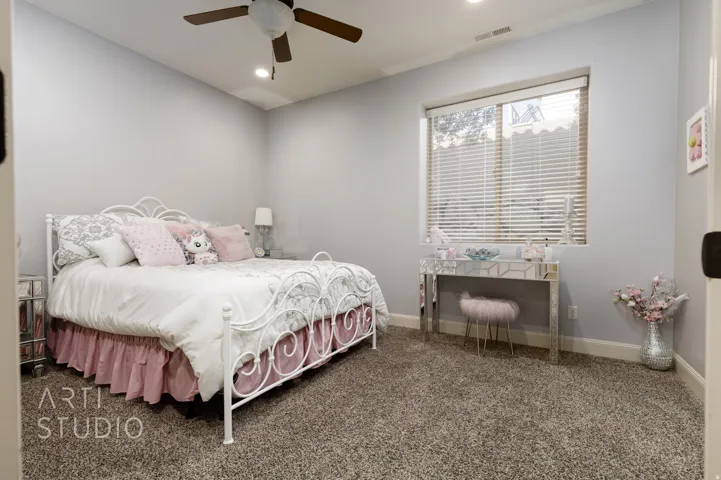 Spacious room featuring neutral carpeting, light gray walls, a ceiling fan with integrated lighting, recessed overhead lighting, and a window with blinds