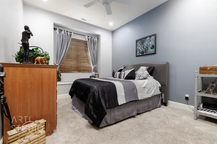 Carpeted bedroom featuring a window with built-in bench seating