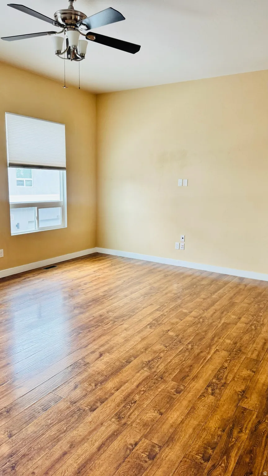 Spacious room featuring wood-finish flooring and neutral wall tones