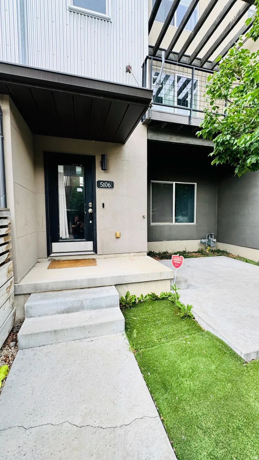Modern facade featuring corrugated metal siding and a dark accent canopy