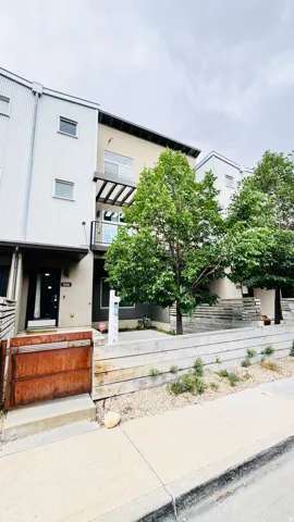 Modern multi-level exterior featuring corrugated metal siding and a recessed balcony