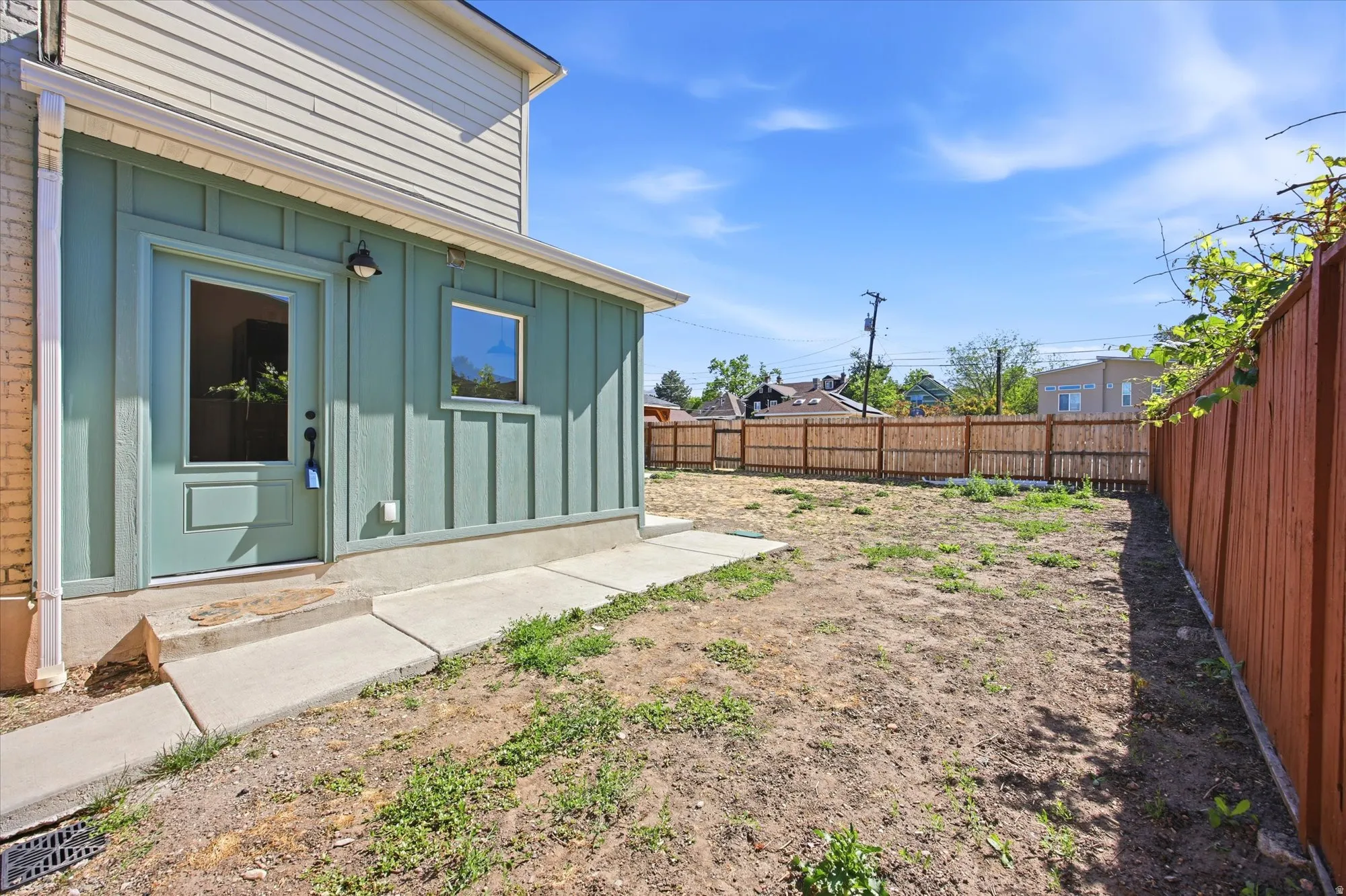 Rear exterior featuring a board and batten addition with a light teal door and window