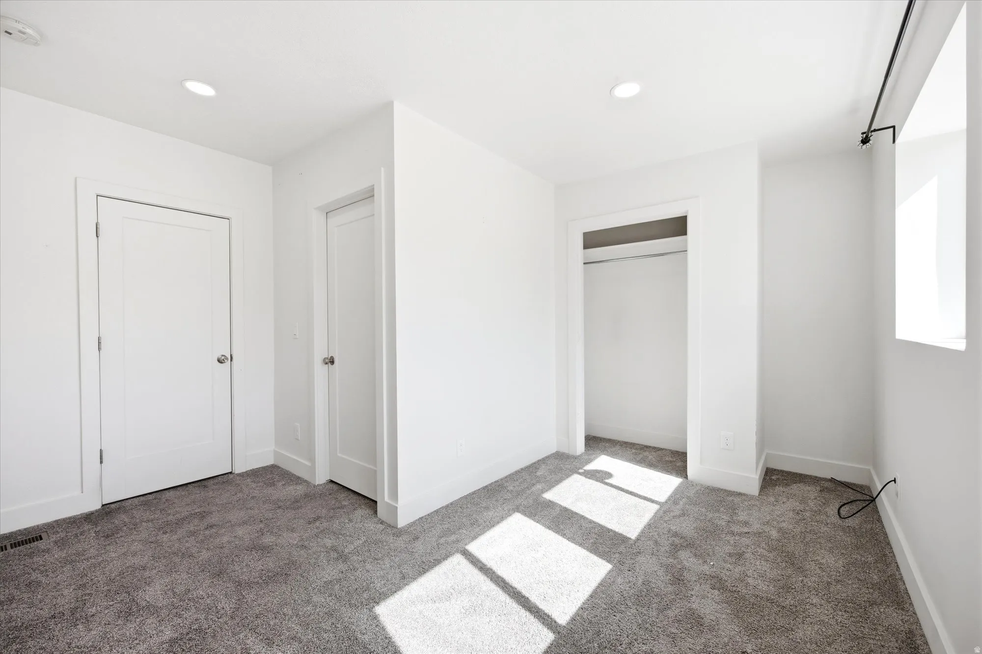 Neutral-toned carpet flooring complements the bright white walls and trim