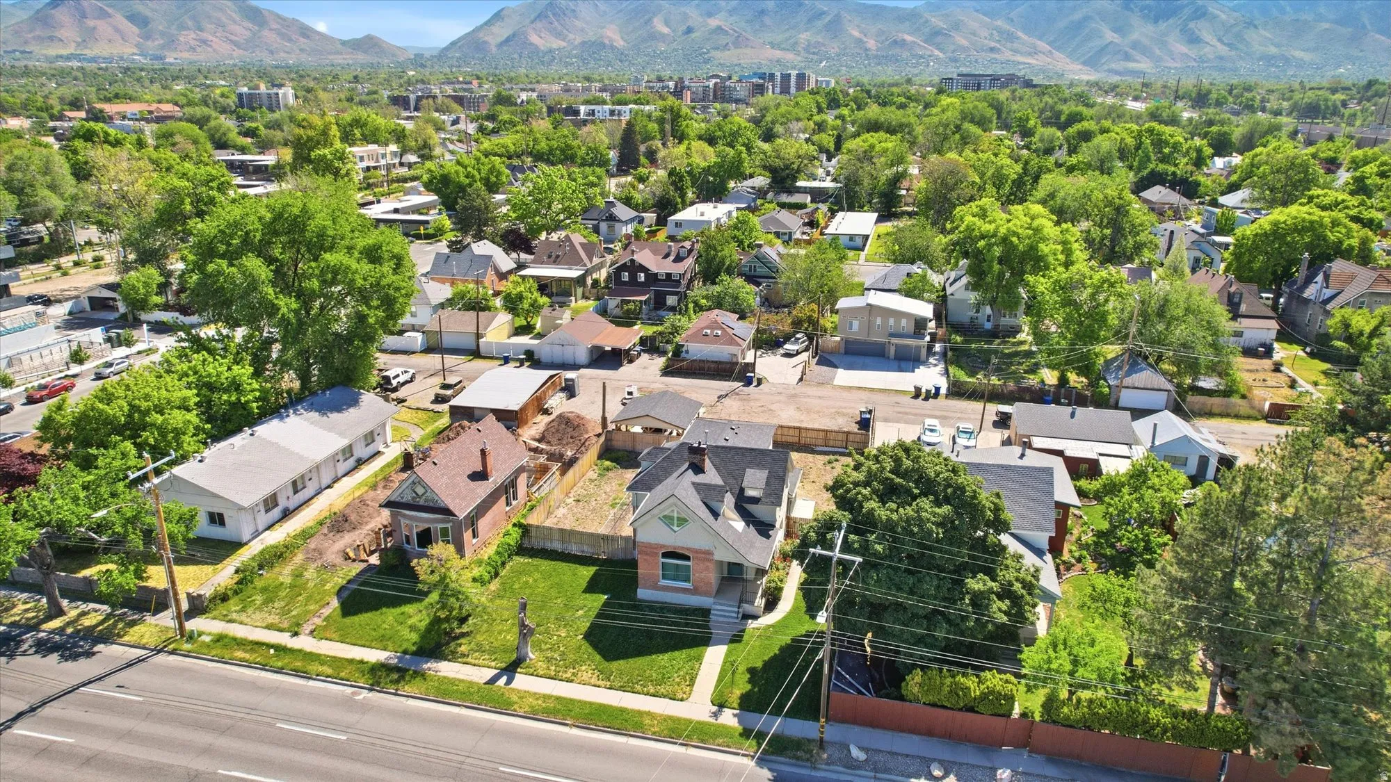 Brick exterior residence with a pitched roof, front yard, and mature trees