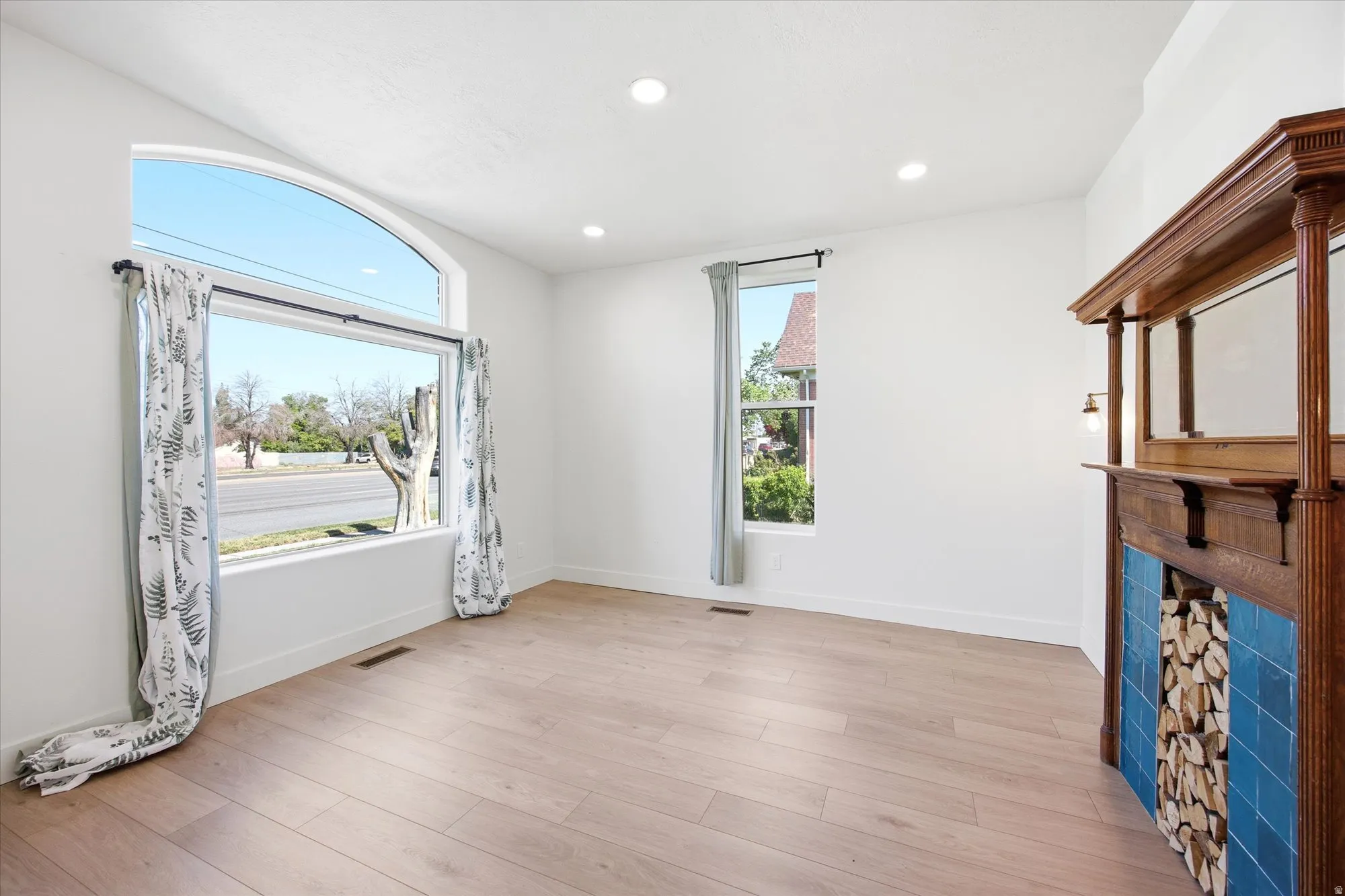 Spacious room featuring wood-finish flooring, recessed lighting, and white walls