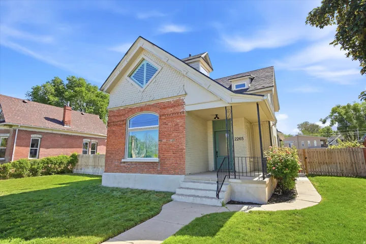 Brick and shingle-sided exterior with a covered porch and front yard