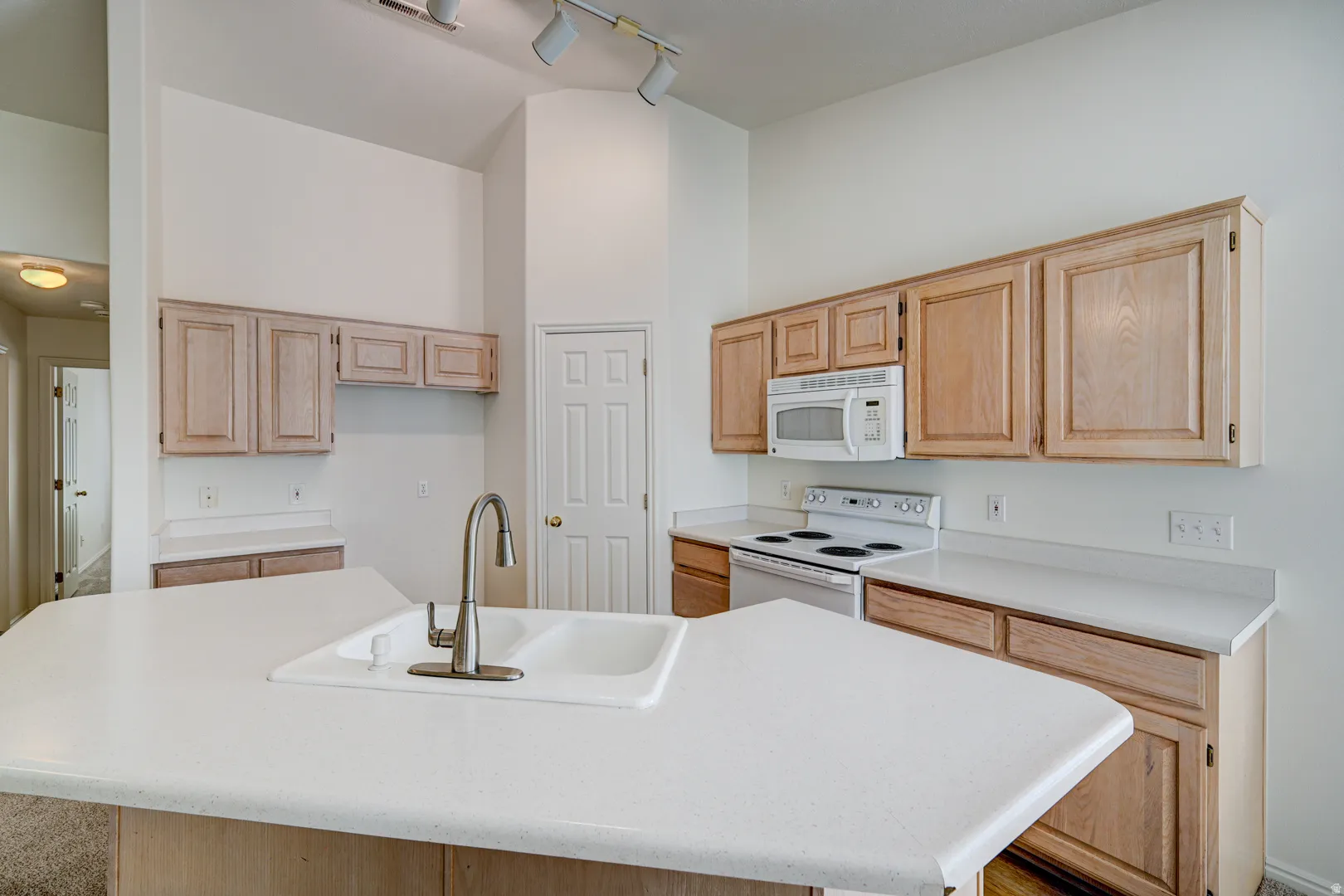 Kitchen island featuring a double basin sink and gooseneck faucet