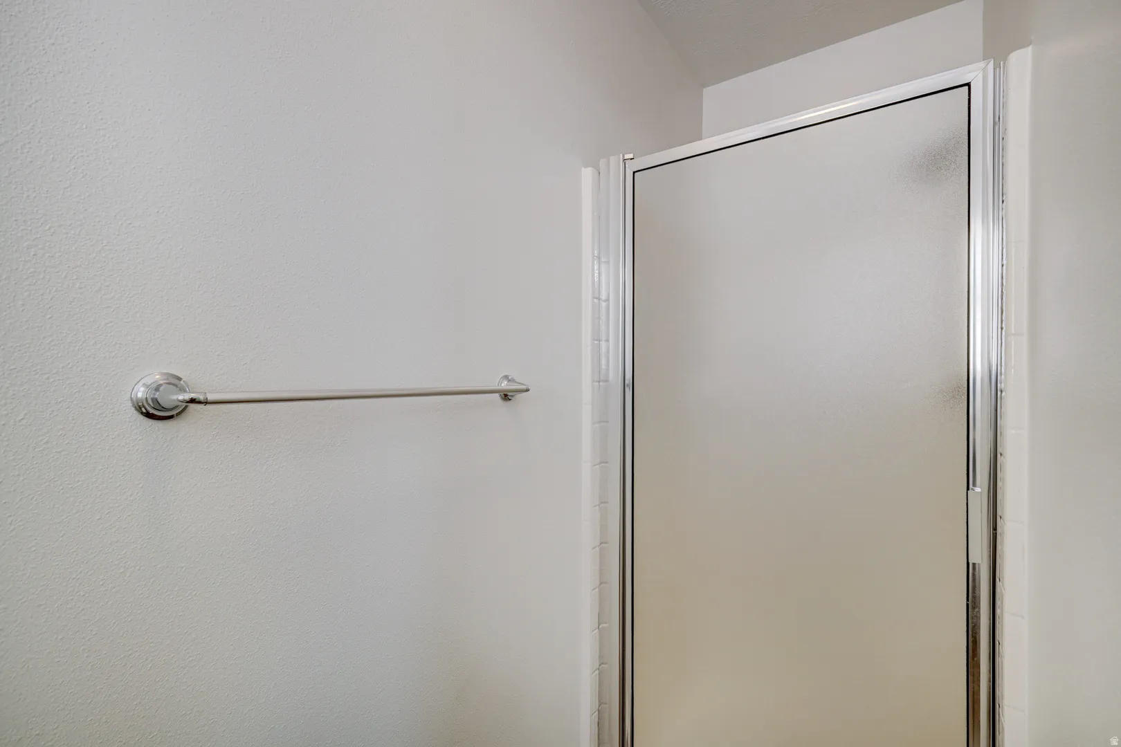 Primary Bathroom with Frosted glass shower enclosure with polished chrome framing and a coordinating towel bar