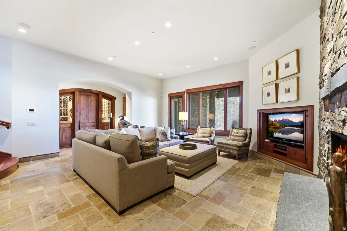 Spacious living area featuring stone tile flooring and a built-in media center