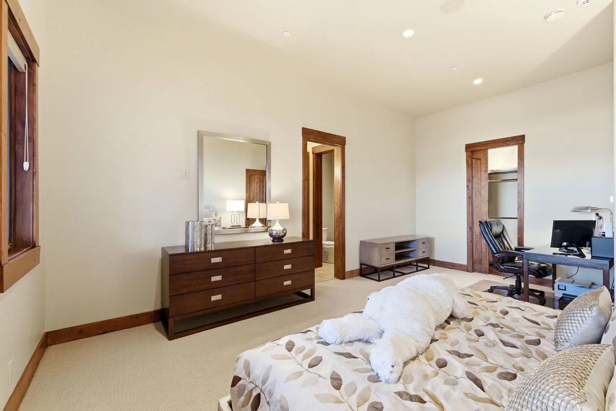 Spacious room with light neutral wall tones, recessed lighting, wood-trimmed window, wood-trimmed doorway, and a built-in closet with wood trim