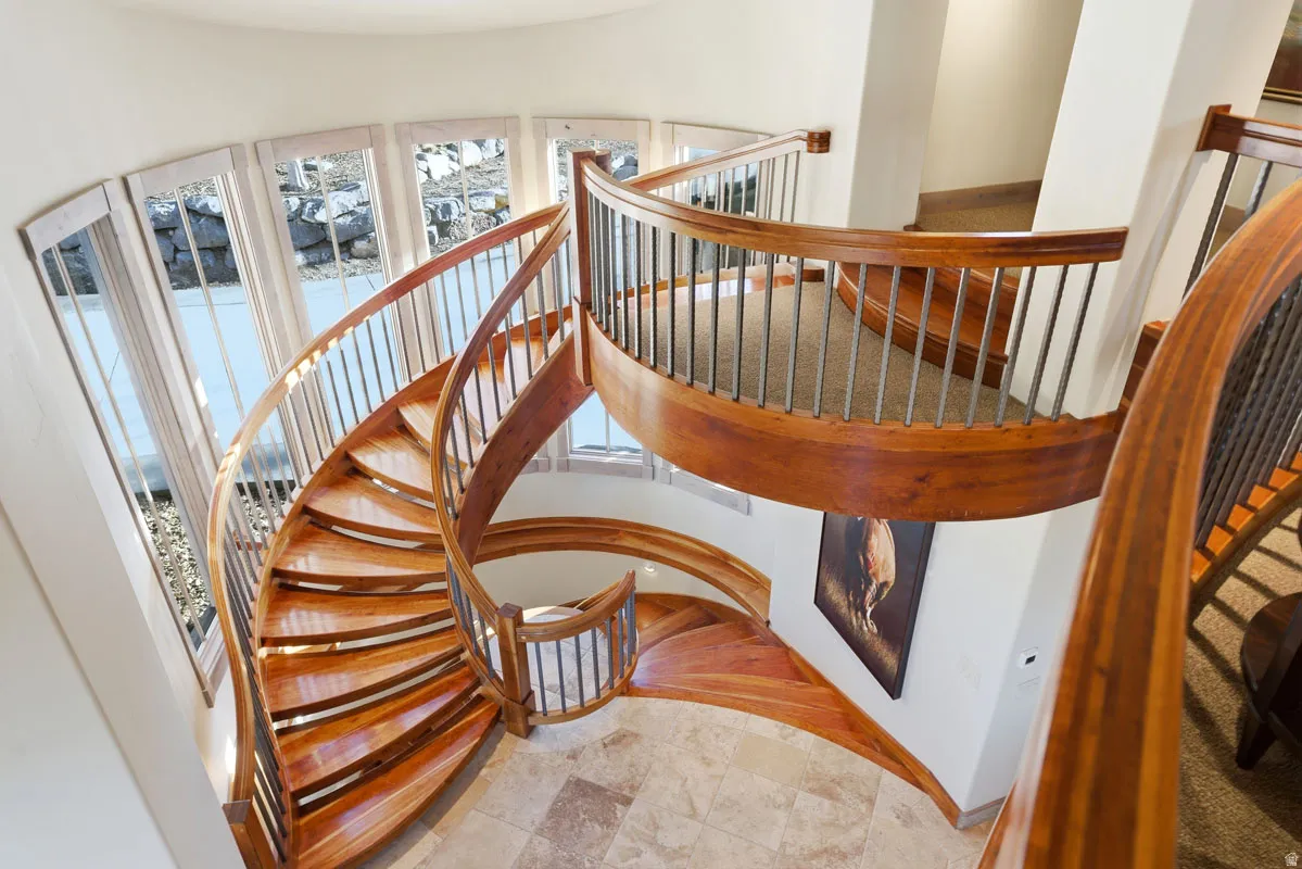 Custom spiral staircase with rich wood-finish treads and handrails