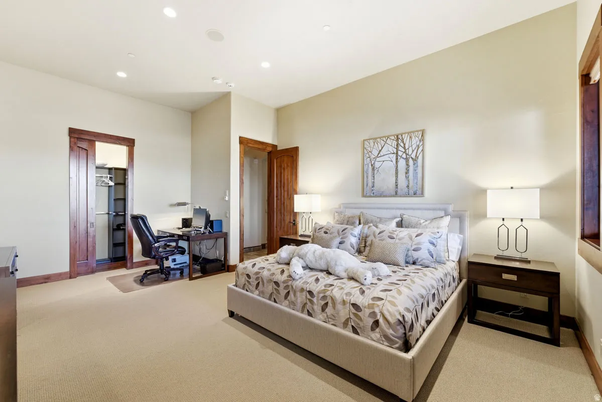 Spacious room featuring neutral carpeting, recessed lighting, wood-finish trim, and a built-in closet with shelving and hanging rods