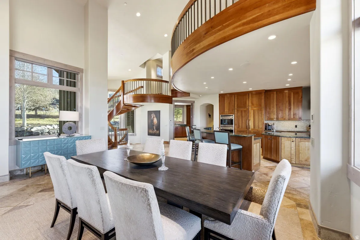 Dining area featuring high ceilings, large windows, and stone-finish flooring