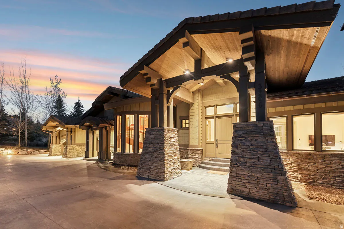 Stone and timber-frame entryway featuring a prominent porte-cochère with recessed lighting