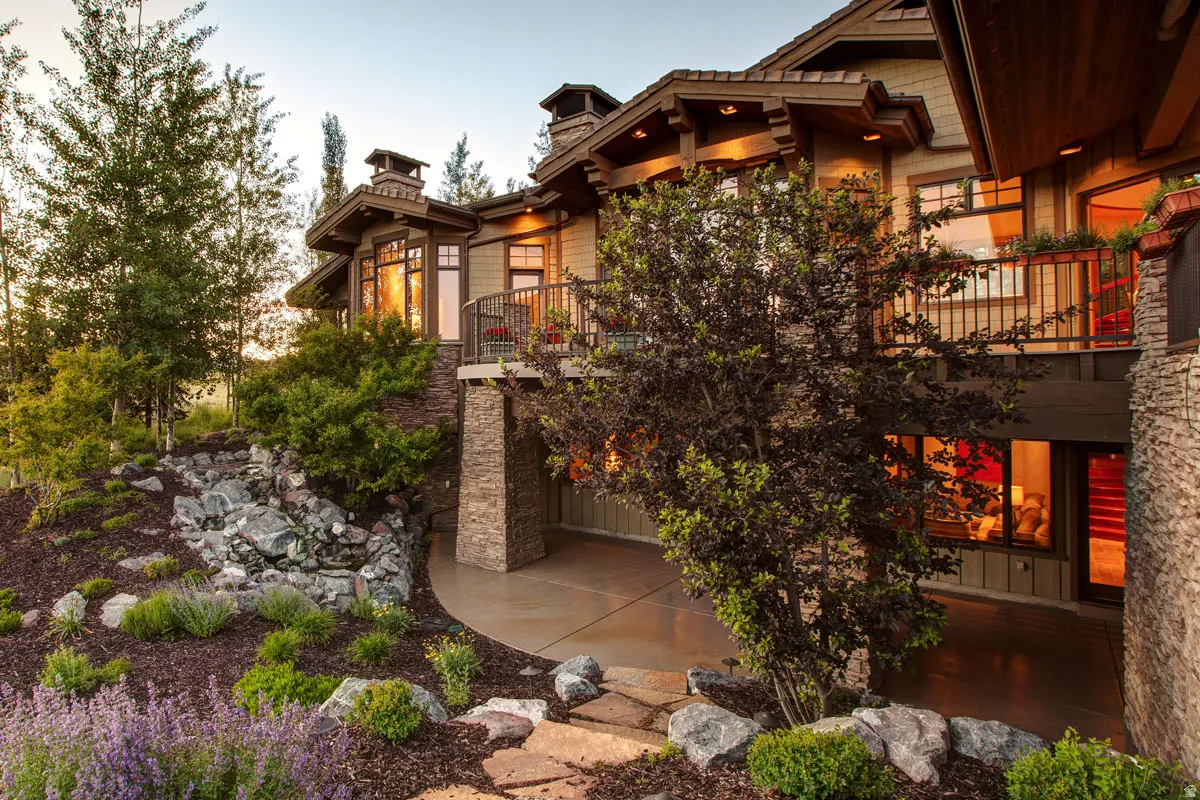 Multi-level residential exterior featuring extensive stone accents and wood siding