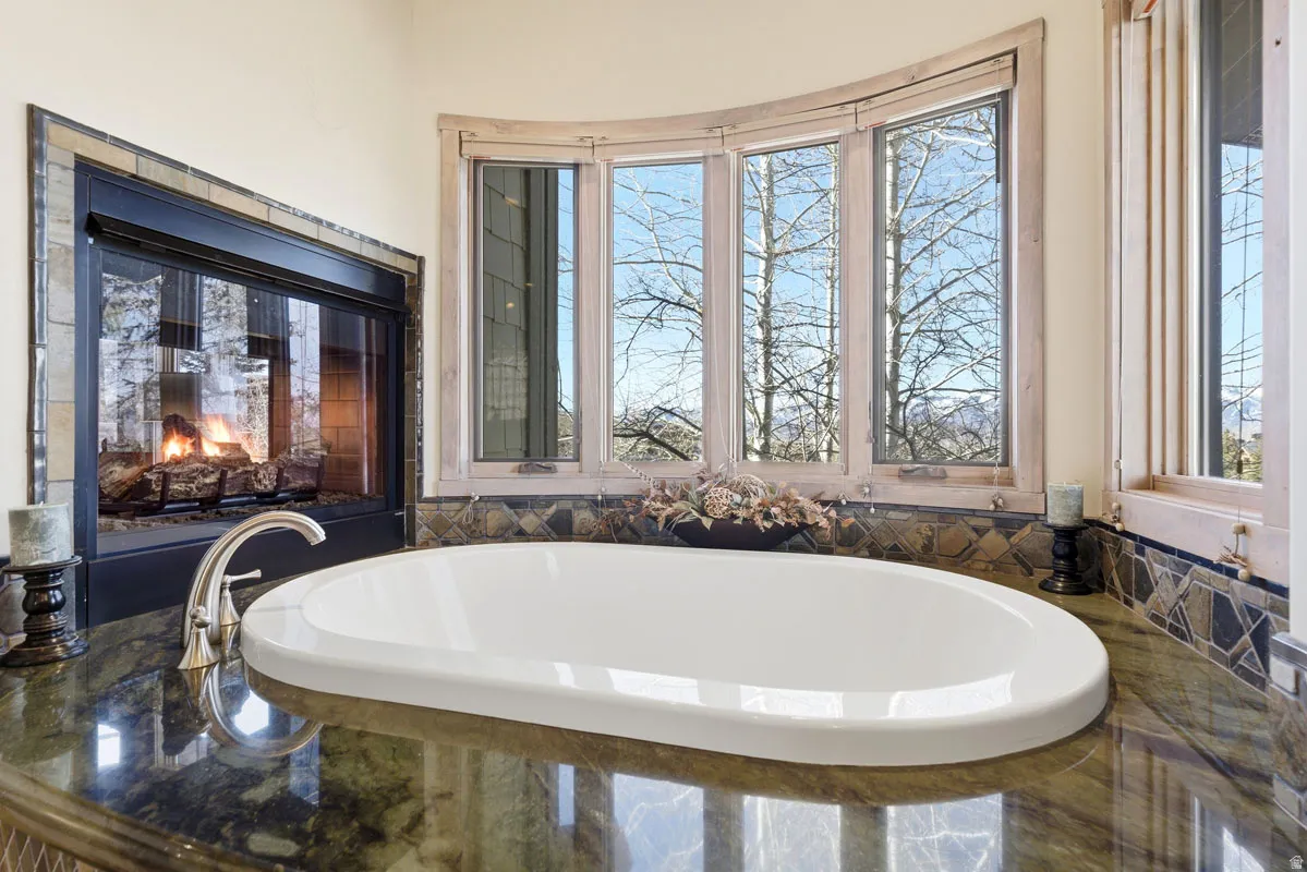 Soaking tub with polished chrome faucet set into a dark stone countertop