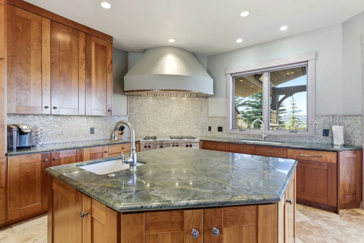 Kitchen featuring a spacious multi-sided island with an undermount sink and a gooseneck faucet