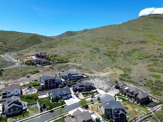 Residential development nestled into a verdant hillside, featuring multiple distinct homes with varied architectural styles