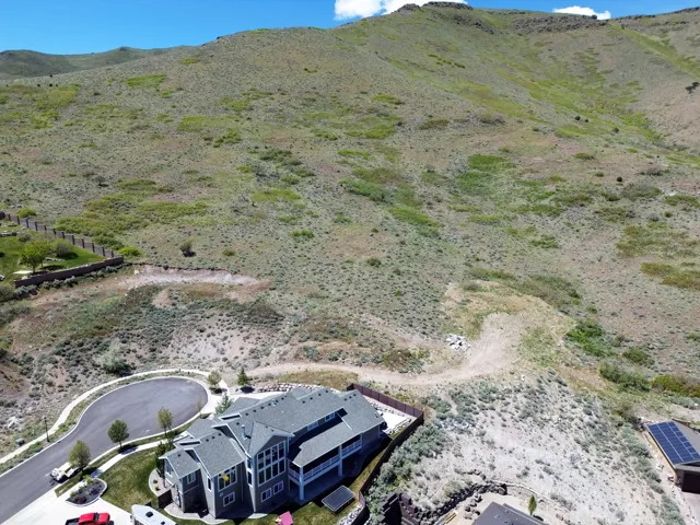 Expansive residential lot featuring a sloped terrain and partial fencing