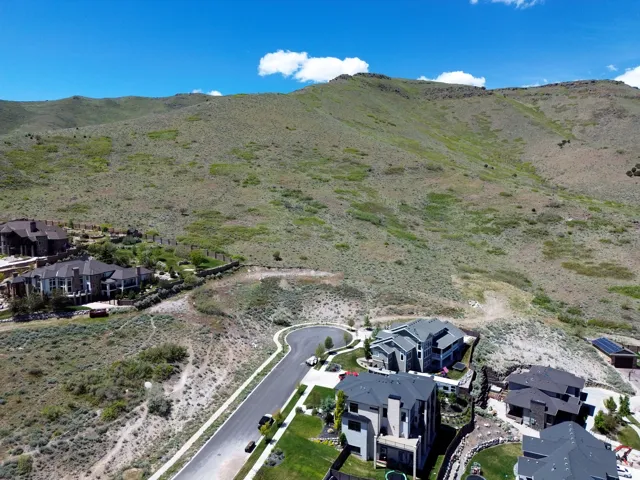 Aerial perspective showcasing a residential community nestled against a verdant mountain backdrop