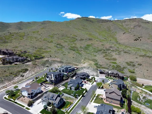 Aerial perspective showcasing a residential community nestled against a verdant mountainside