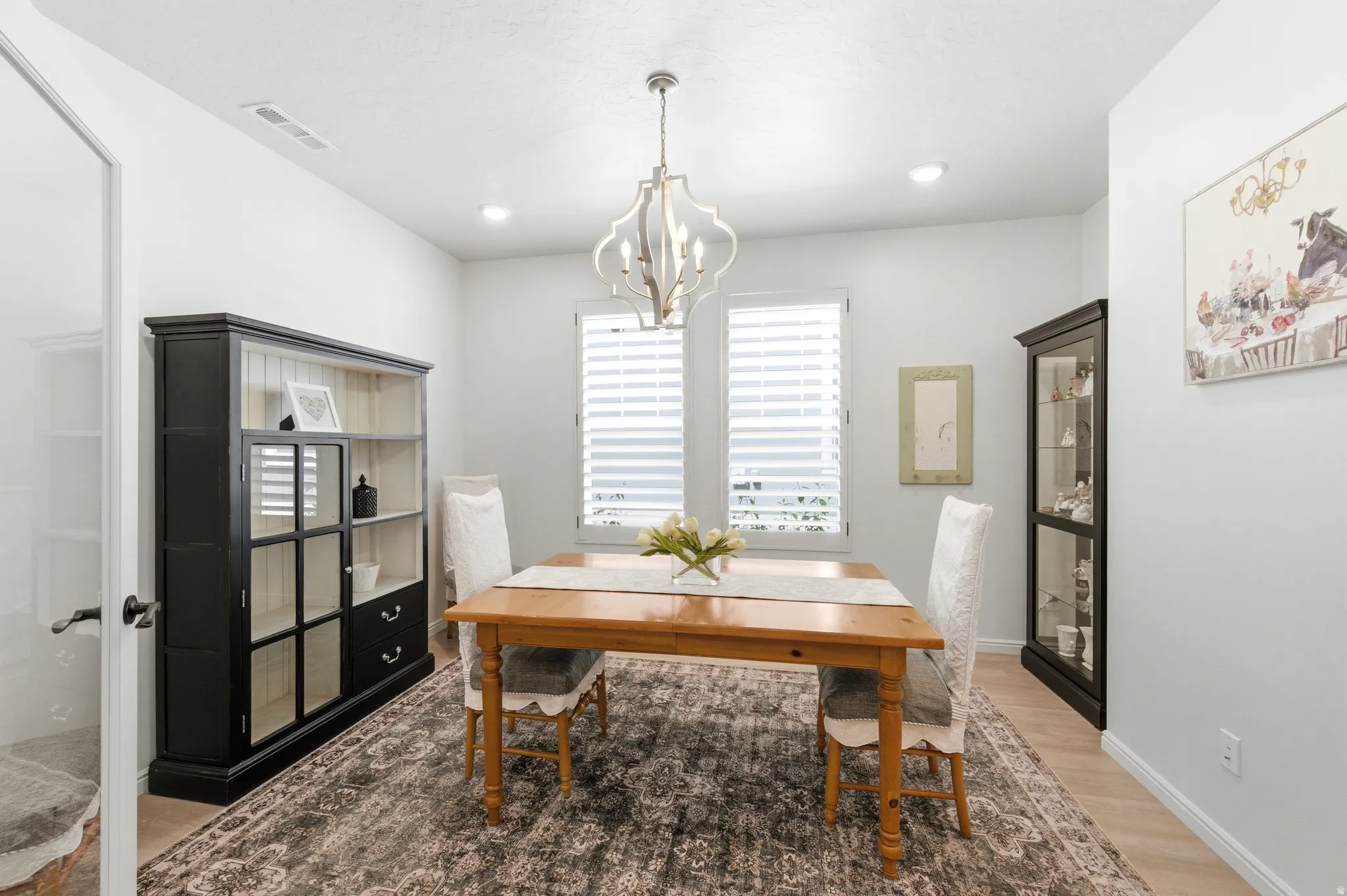 Dining area featuring light wood-finish flooring and a central area rug
