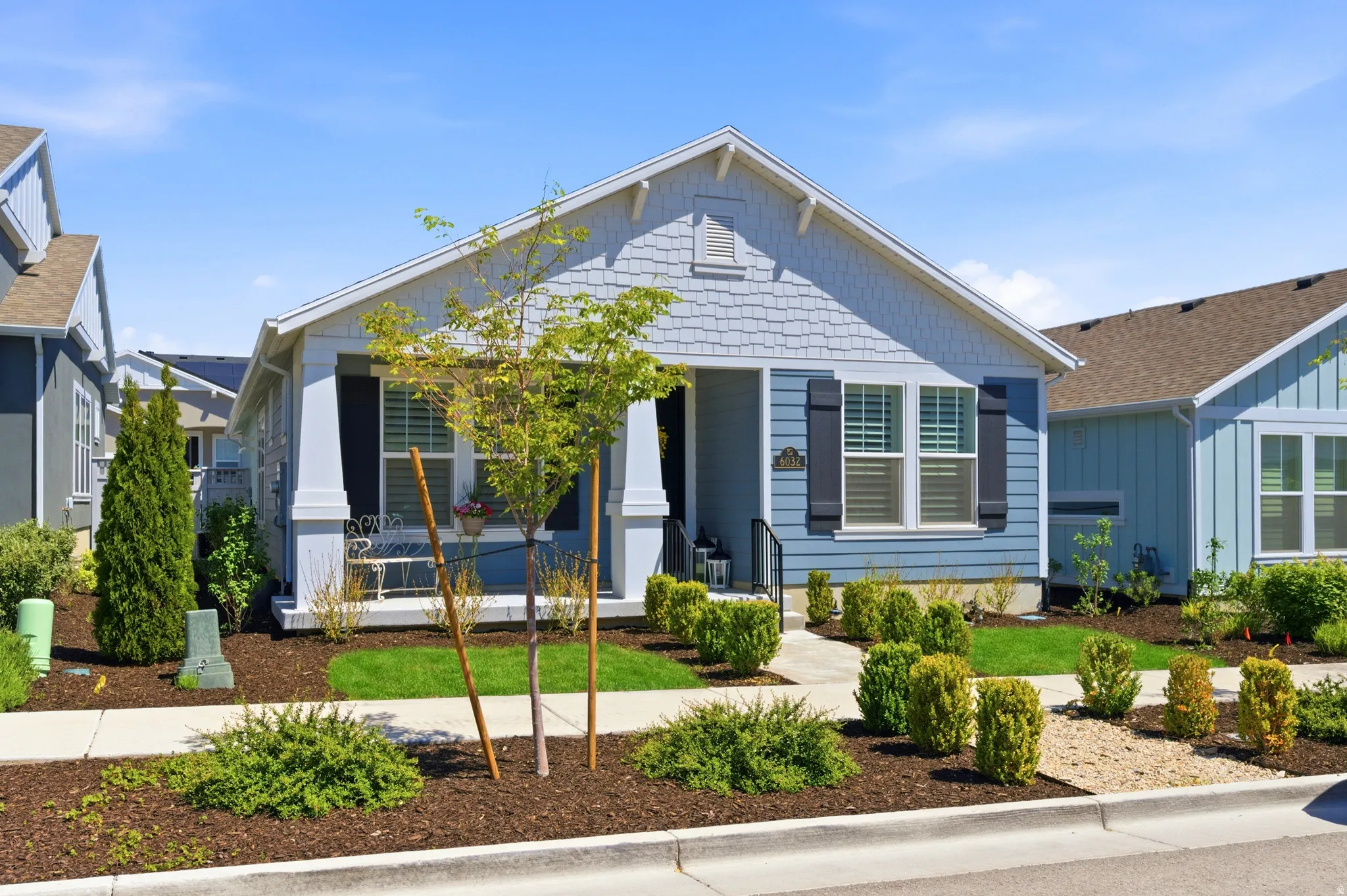 Light blue siding exterior with white trim and dark louvered shutters