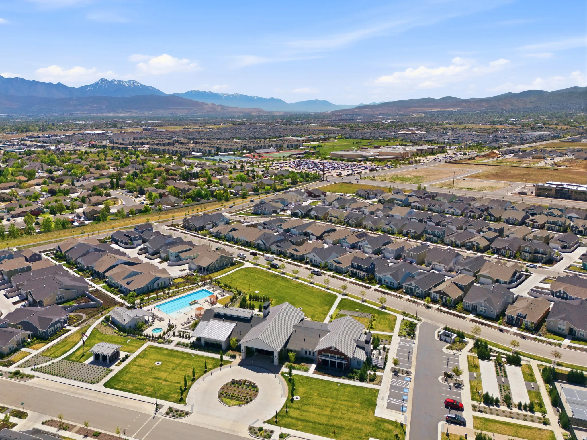 Expansive residential development featuring numerous single-family homes, a community clubhouse, and a swimming pool