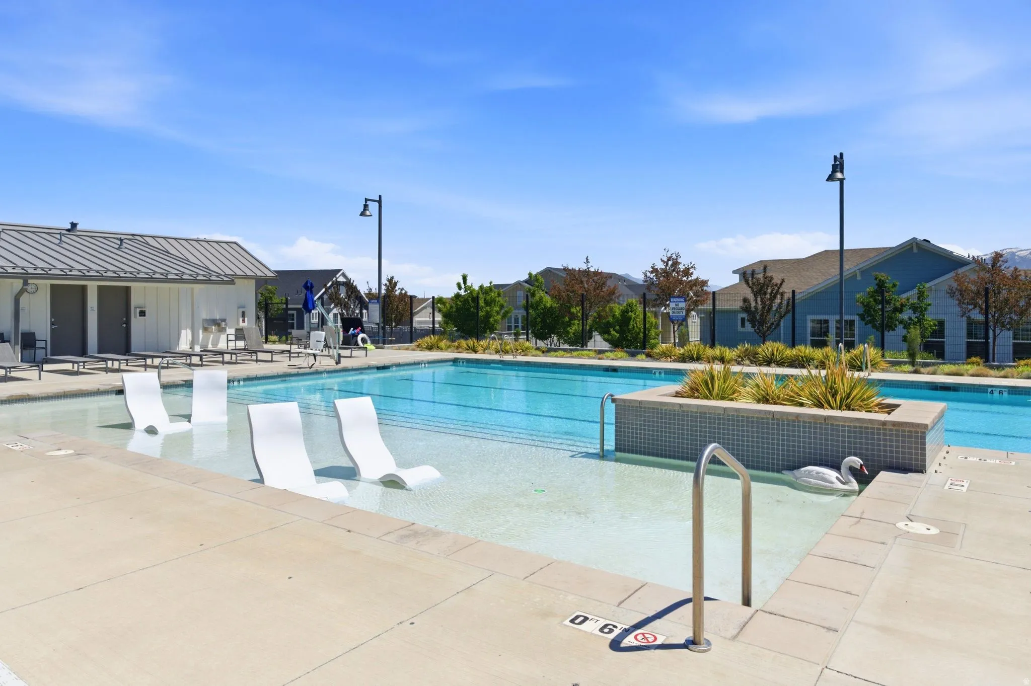 Outdoor swimming pool featuring a shallow entry area, integrated seating, and a tiled planter box