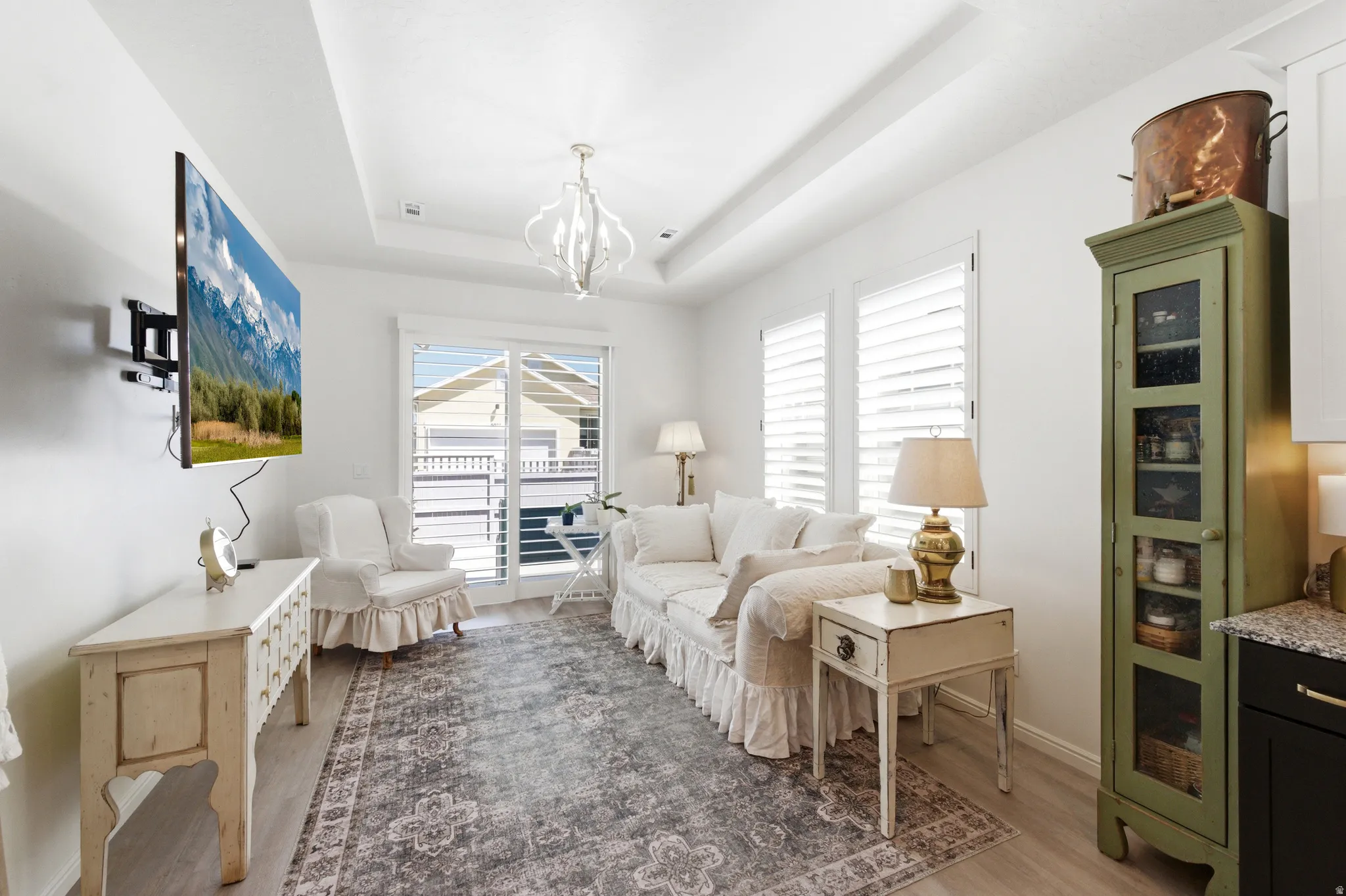 Living area featuring a tray ceiling and light wood-finish flooring