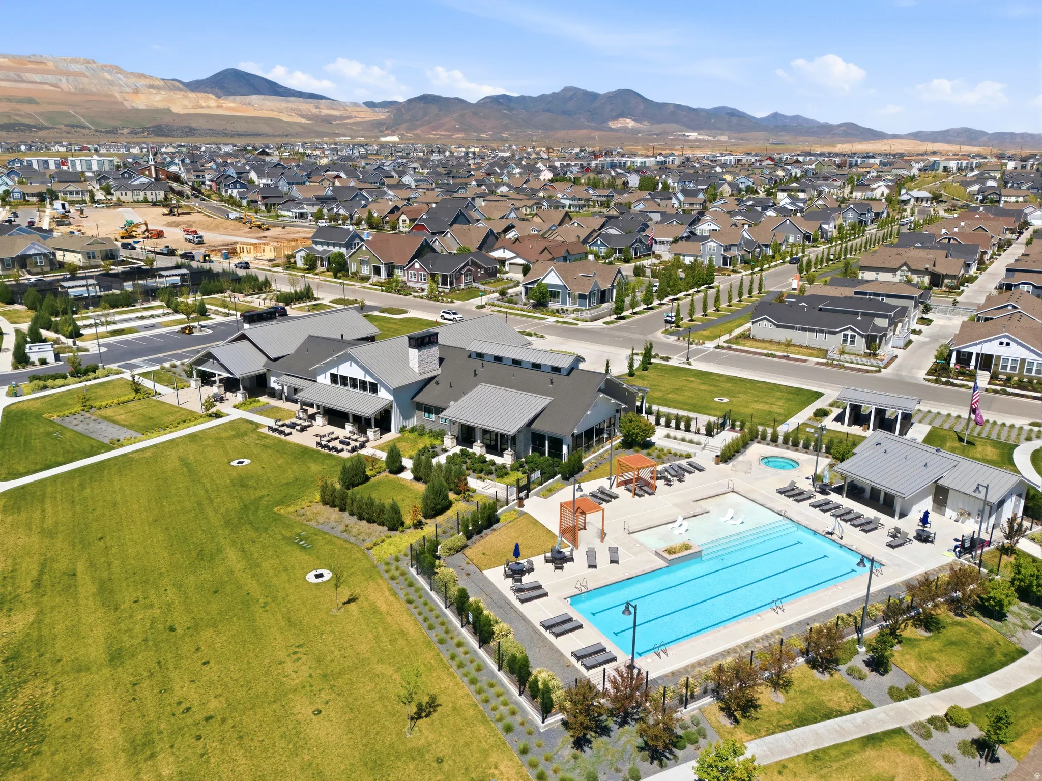 Community amenities featuring a large outdoor swimming pool, integrated hot tub, and surrounding lounge areas