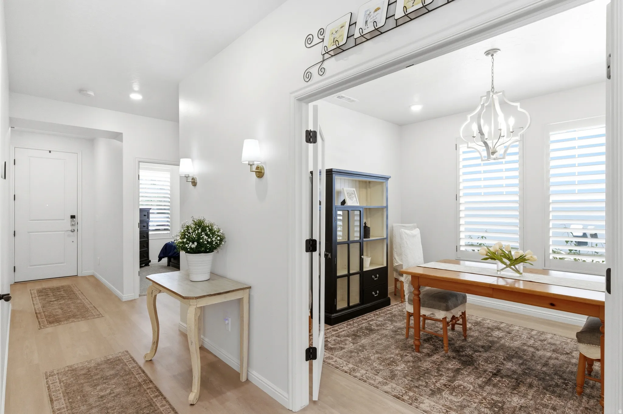 Bright entryway featuring wood-finish flooring, recessed lighting, and wall sconces